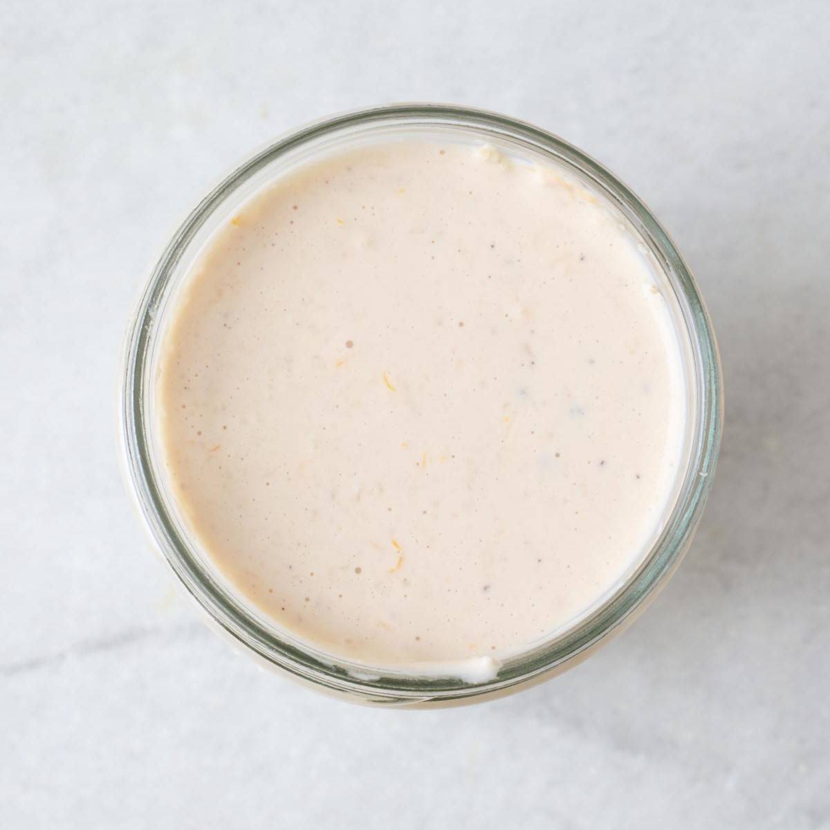 Creamy Caesar dressing in a small jar.